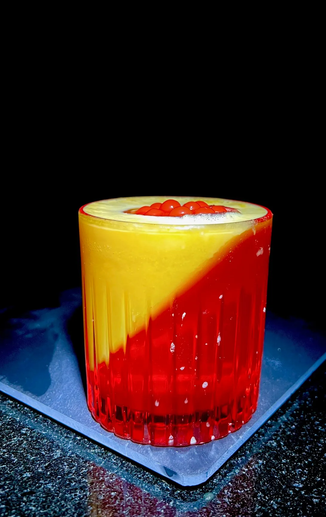 A red and yellow drink sitting on top of a table