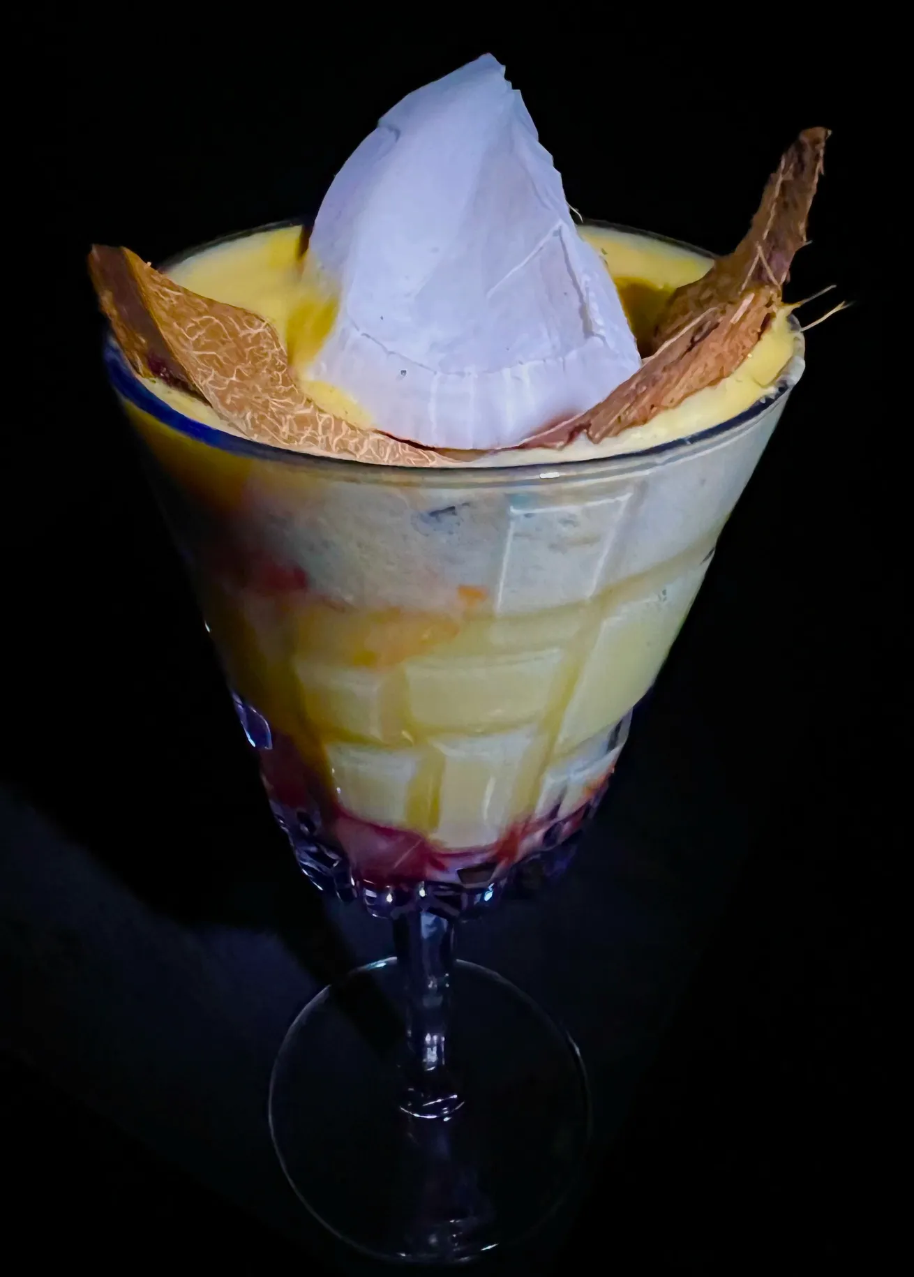 A dessert in a glass on a black background